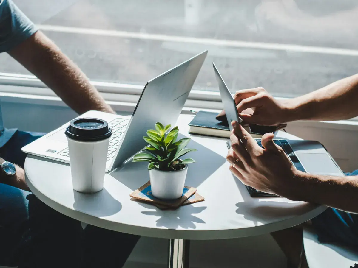 Ondernemer en bureau overleggen aan tafel met laptop en tablet